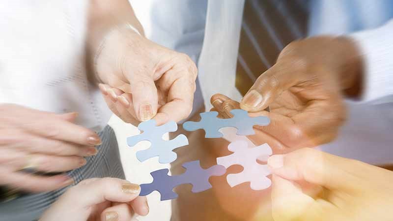 group of people holding pieces of a jigsaw