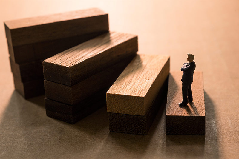 small model man standing at the bottom of wooden steps