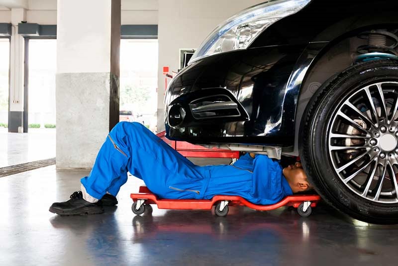 mechanic under a car bonnet