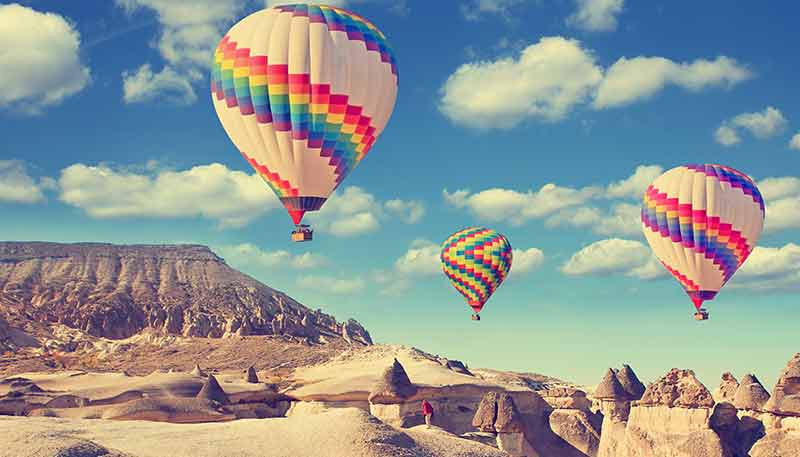 hot air balloons flying over a desert