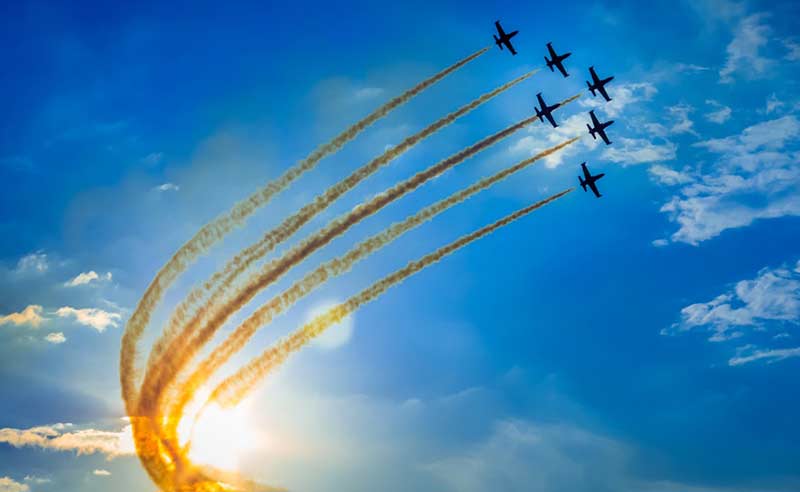 six planes flying in a formation with smoke trails